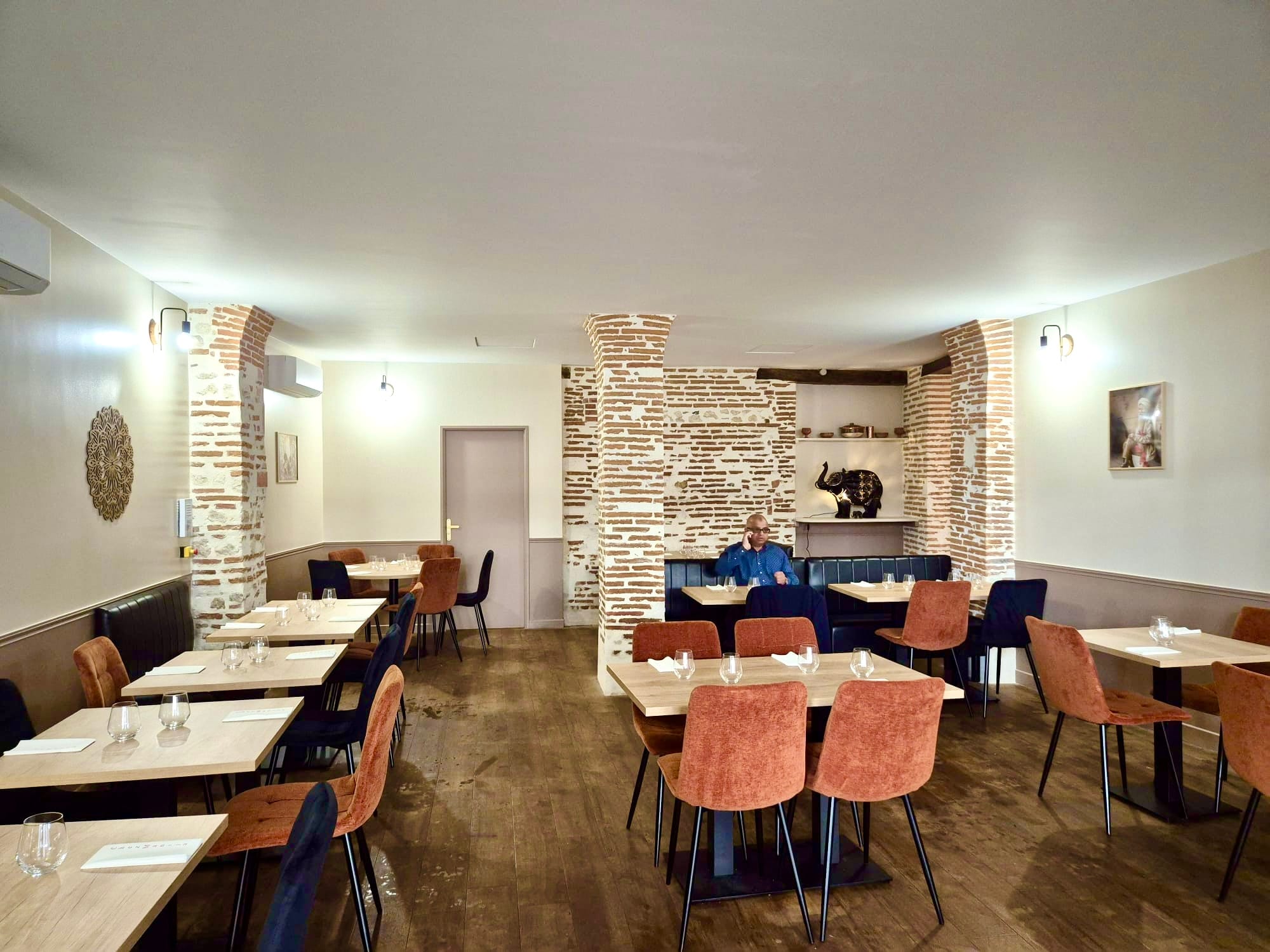 Dining room with exposed brick pillars and a carved elephant statue