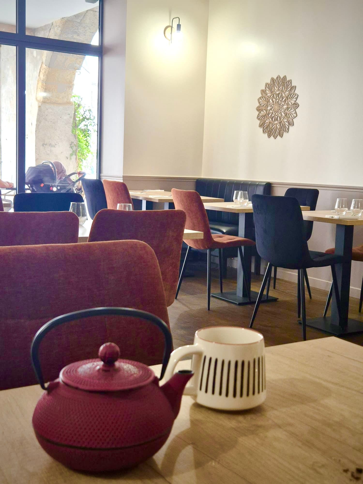 Cast-iron teapot and mug on a table beside cozy banquette seating